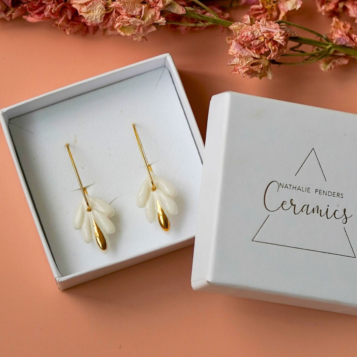 Dormeuses lys céramique et or dans leur écrin blanc, bijou cadeau