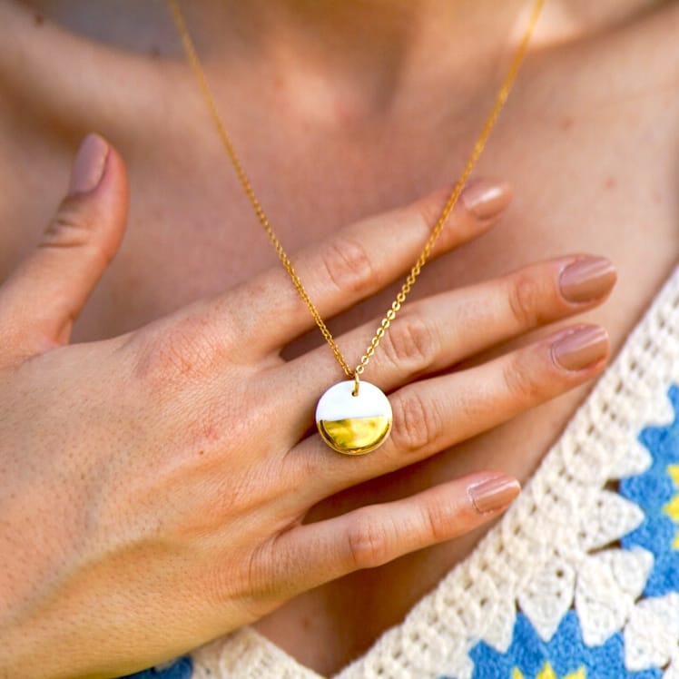 collier rond en porcelaine blanche et or sur chaîne dorée portée